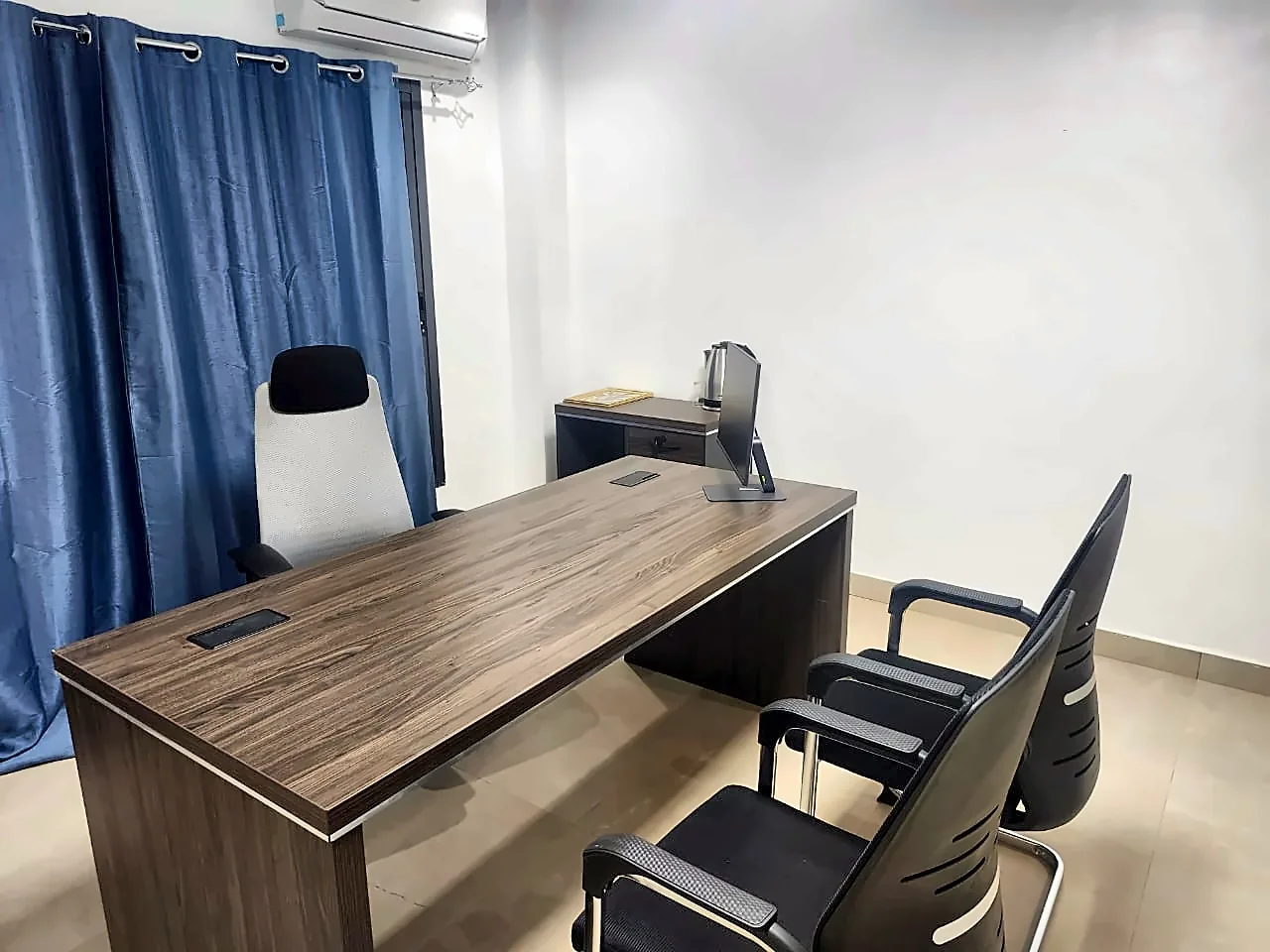 Bureau de direction en location à Bamako avec écran, fauteuil ergonomique et chaises visiteurs