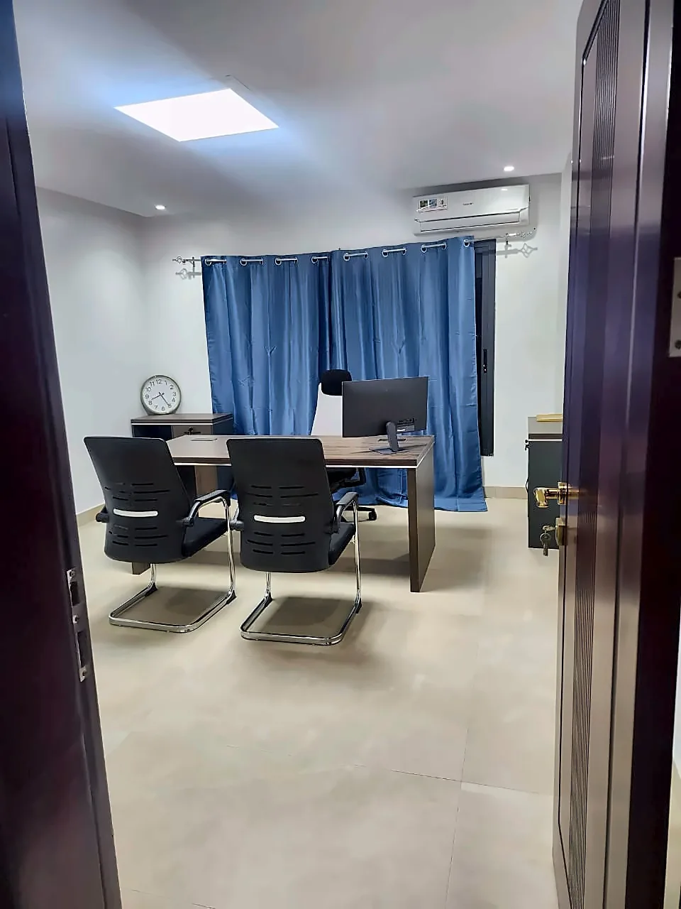 Bureau privé climatisé à Bamako vu depuis la porte, avec éclairage LED et rideaux