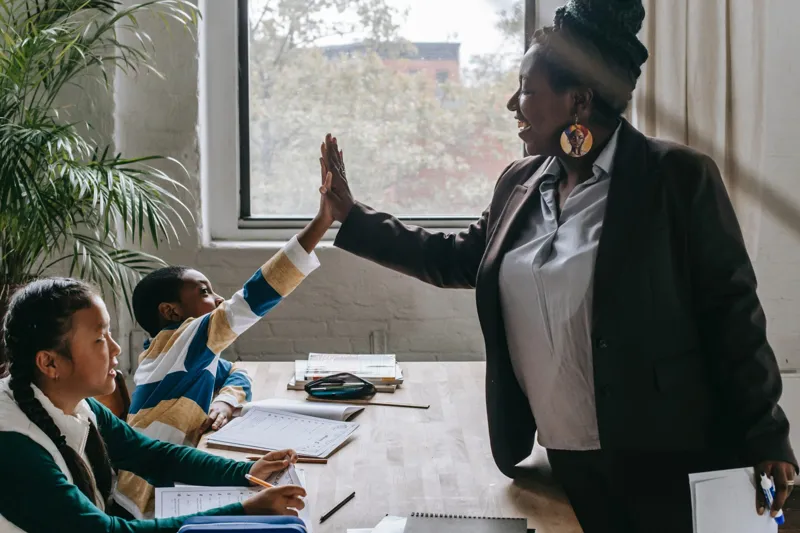 Professeure de soutien scolaire félicitant un élève en 10e année à Bamako